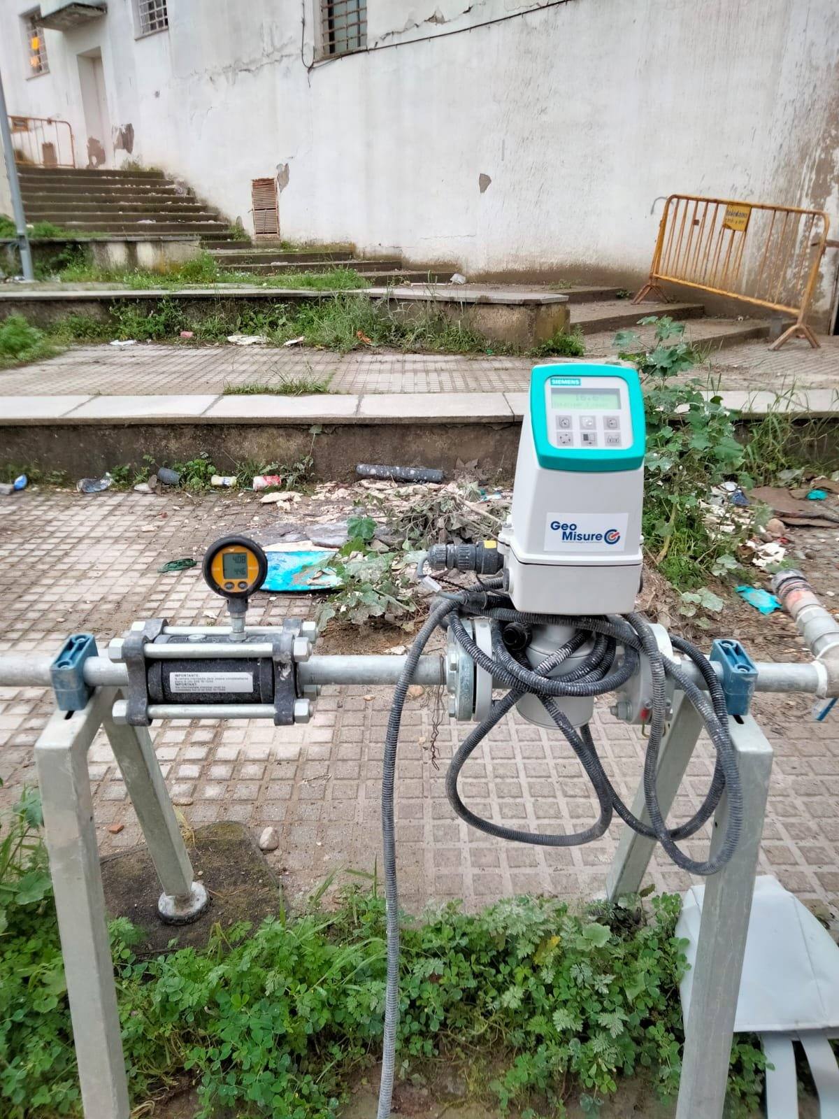 Caudalímetro electromagnético y manómetro digital montados en la línea de inyección, sobre un bastidor de acero en el acerado.