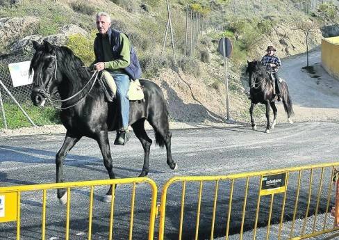 Dos jinetes recorren la variante del camino del Realejo ya terminada, junto al vallado de obra.