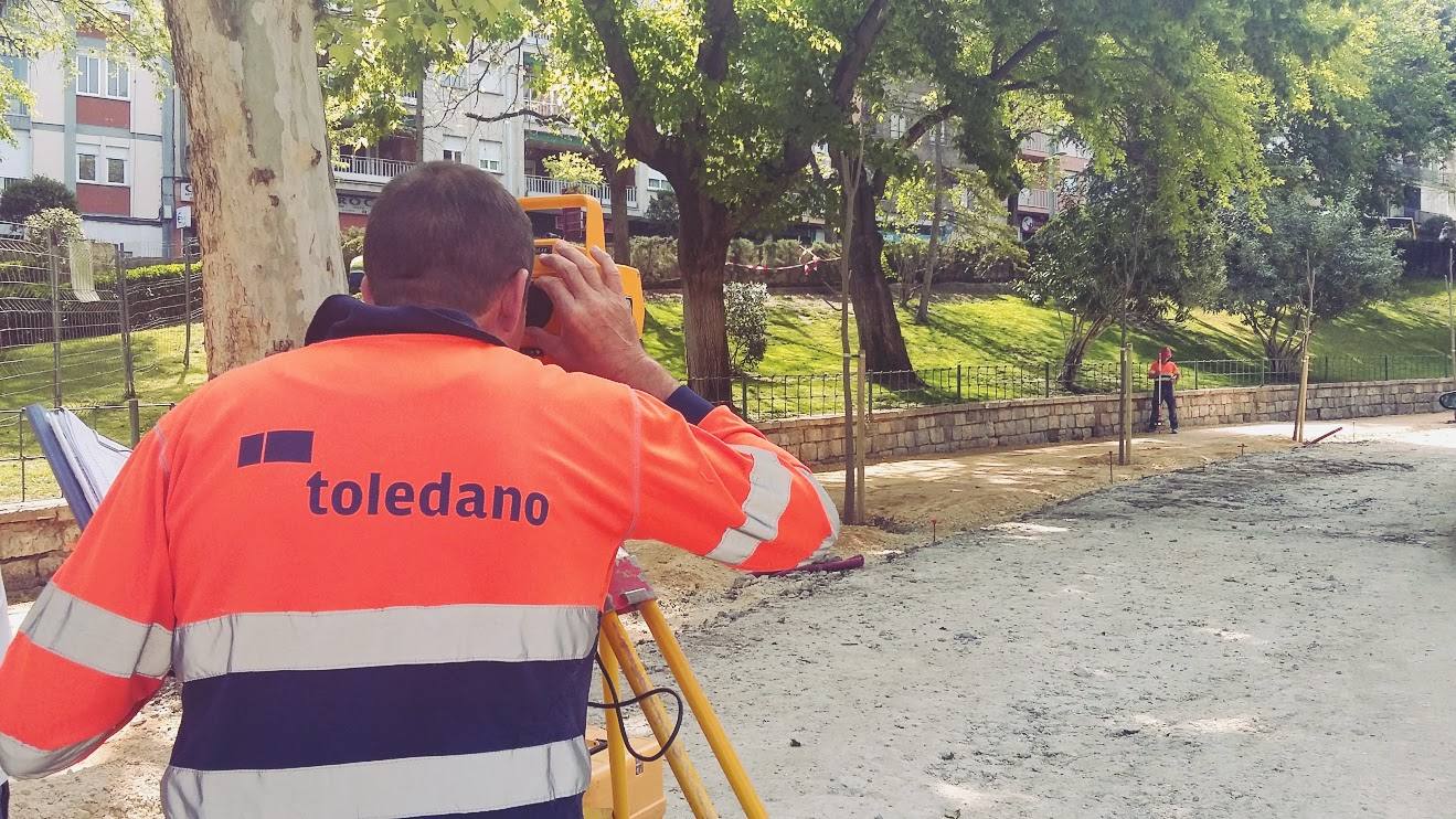 Técnico de Toledano con chaleco de alta visibilidad realizando un replanteo con nivel topográfico en el Paseo de las Bicicletas.