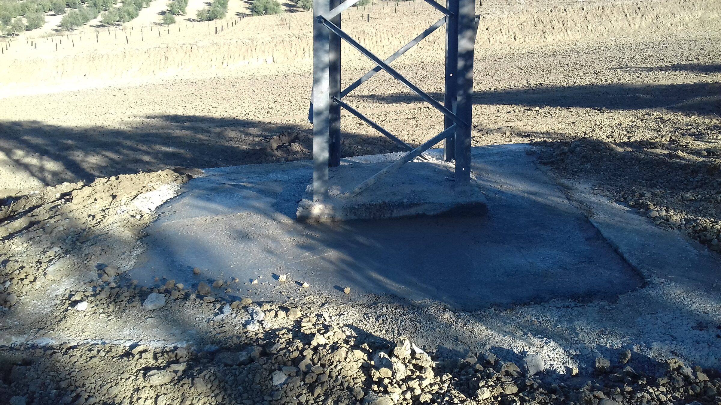 Base del apoyo terminada, con una losa de hormigón fresco que cubre la cimentación alrededor de las patas de la torre.